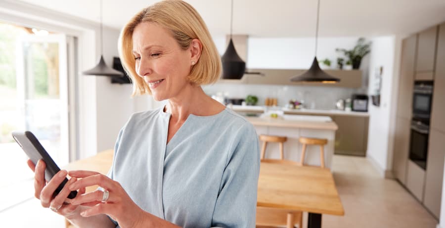 Woman holding a cell phone in a stylish home
